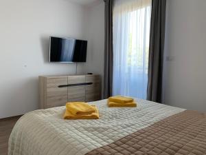 een slaapkamer met een bed met twee gele handdoeken erop bij Naplemente Apartman in Balatonfüred