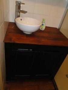 a white sink on a wooden counter in a bathroom at Ty Clara in Landéda