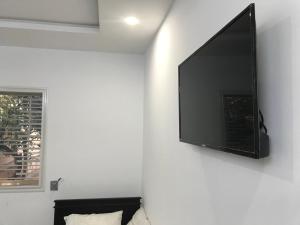 TV de pantalla plana colgada en una pared blanca en Maison de Vacances Tazarka, en Tazarka