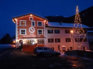a building with a christmas tree in front of it at Hotel Chavalatsch in Müstair