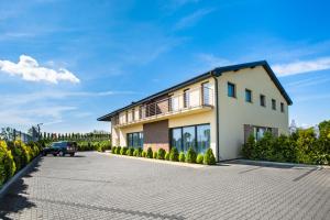 a house with a car parked in the driveway at Złoty Staw in Gdańsk