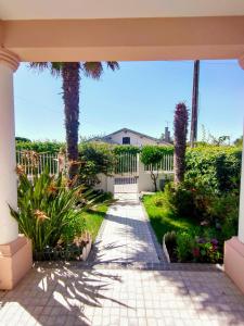a patio with a white fence and palm trees at Villa Shardana B&B in Sesimbra