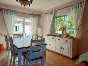 a dining room with a table and blue chairs at Villa Shardana B&B in Sesimbra