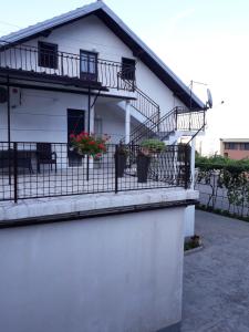 Una casa blanca con 2 balcones y flores. en Kuća za odmor Varoš, en Vrlika