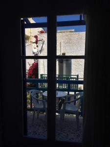 Blick auf einen Tisch und Stühle durch ein Fenster in der Unterkunft Hotel Elizabeth in Naxos Chora