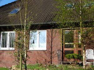 a brick house with a chair in front of it at Pension Ziemann in Nartum