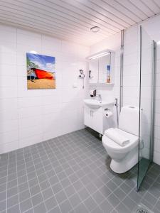 a bathroom with a toilet and a painting on the wall at Hotelli Kuohu Kangasala - Hotel and Apartments by UHANDA in Kangasala +38 photos