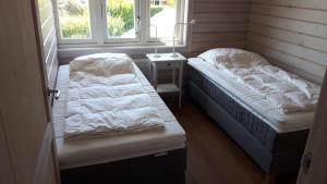 ein Zimmer mit zwei Betten und einem Nachttisch und zwei Fenstern in der Unterkunft The Blue House - Luxurious Waterfront Villa Zeewolde in Zeewolde + 9 Fotos