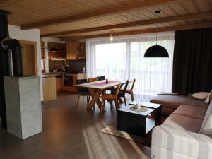 a living room with a table and a kitchen at STONEGALLERY in Ždiar