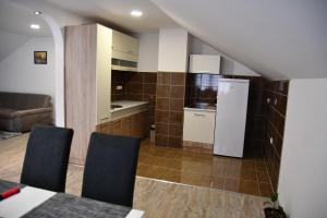 cocina con nevera, mesa y sillas en Apartman Karganovic, en Višegrad