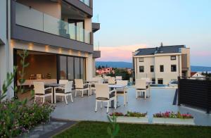 a patio with tables and chairs on top of a building at Pansion Leggero in Krk