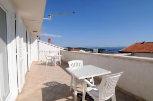 eine Terrasse mit Tisch und Stühlen auf einem Balkon in der Unterkunft Villa Zvonko in Makarska