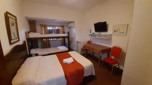 a hotel room with a bed and a desk and a television at Hotel Gaviota in Montevideo