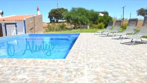 eine Reihe von Stühlen neben einem Pool in der Unterkunft Monte O Alentejo in Ourique