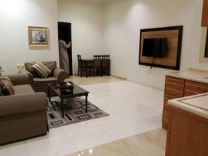 uma sala de estar com um sofá e uma televisão em شقق النرجس فيلا للشقق المخدومة em Riyadh