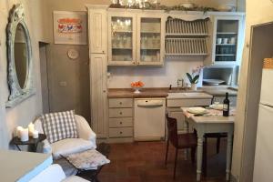 eine Küche mit weißen Schränken und einem Tisch mit Stühlen in der Unterkunft Nido verde in Montefollonico