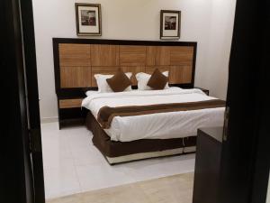 um quarto com uma cama grande e uma cabeceira em madeira em شقق النرجس فيلا للشقق المخدومة em Riyadh