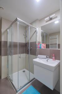 a bathroom with a glass shower and a sink at Bright Studio, 10min Centre, Free Parking in Prague