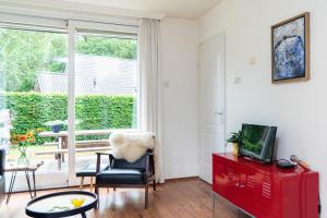 a living room with a red cabinet and a window at Vakantiehuisje Specht in Otterlo