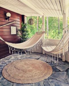 a porch with two hammocks and a rug at Hotelli Hirsiranta in Ruokolahti