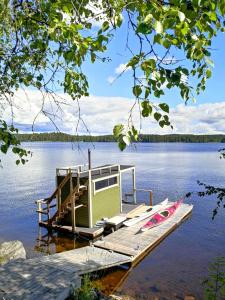 a small boat on a dock on a lake at Hotelli Hirsiranta in Ruokolahti