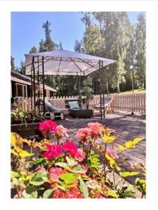 a patio with a white umbrella and some flowers at Hotelli Hirsiranta in Ruokolahti