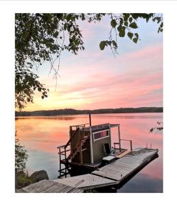 a small boat on a dock on a lake at Hotelli Hirsiranta in Ruokolahti