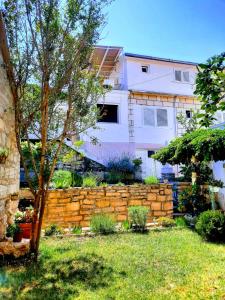 un mur de soutènement en briques devant une maison dans l'établissement Apartments Neno, à Korčula