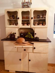kuchnia z białymi szafkami z otwartymi drzwiami w obiekcie Wiśniowy Młyn w mieście Wiśniowa