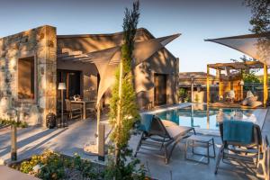 a patio with chairs and a swimming pool at River Villas Parga in Parga