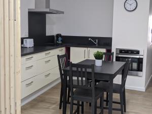 eine Küche mit einem Tisch und Stühlen in einer Küche in der Unterkunft Appartement 10A - RDC-centre ville-local vélo in Malestroit + 4 Fotos