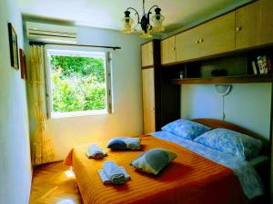 a bedroom with a bed with towels and a window at Apartments Neno in Korčula