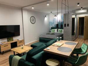 a living room with a green couch and a table at Marina Green Loft in Ełk
