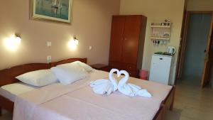 two swans are sitting on top of a bed at George Studios in Vasiliki