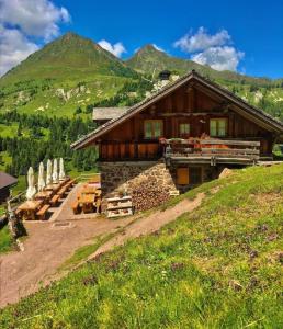 a log cabin with tables and chairs in front of it at Casa "Berto e Costantina" in Tregiovo