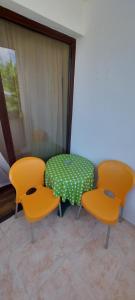 two chairs and a table with a green and white table at Къща за гости ЕЛИ in Primorsko