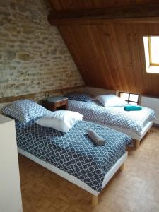 2 camas individuales en una habitación con una pared de ladrillo en LE GRAND CARNOT, en Nolay
