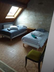 two beds in a room with a window and a chair at LE GRAND CARNOT in Nolay