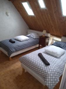 a bedroom with two beds and a wooden ceiling at LE GRAND CARNOT in Nolay