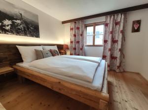 een slaapkamer met een groot houten bed en een raam bij Landhaus im Allgäu in Halblech