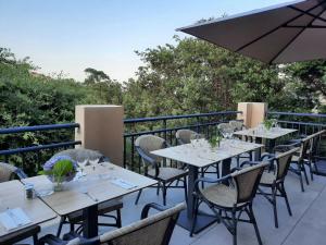a row of tables on a balcony with an umbrella at Hôtel Casa Mea in Bastia