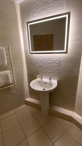 a bathroom with a sink and a mirror at Butterchurn Guest House in Otterburn