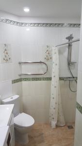 a white bathroom with a toilet and a shower at Jurmala Diamond in Jūrmala