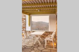 a room with a table and chairs and a window at Marble Art Villas in Panormos
