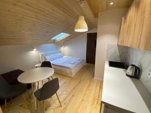 Una pequeña habitación con una cama, una mesa y sillas. en Квартира на вулиці Лесі Українки 19, en Leópolis