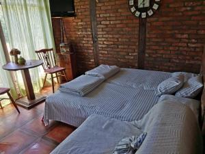 zwei Betten in einem Zimmer mit einer Backsteinwand in der Unterkunft Drinska Tajna in Bajina Bašta