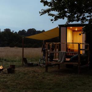 Abbeyfield Horsebox Glamping في موربيث: امرأة تقف أمام خيمة