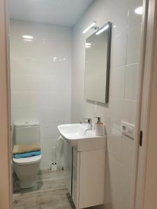 Un baño blanco con lavabo e inodoro. en Patios I, en Peñíscola