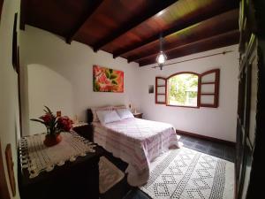 un dormitorio con una cama y una ventana en Fazendinha Paraíso, en Lumiar