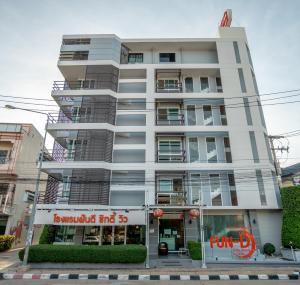 坤敬Fun-D City View SHA Plus的一座高大的白色建筑,前面有一间商店